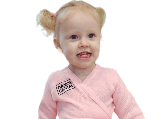 Smiling toddler in a pink Dance Capital wrap top